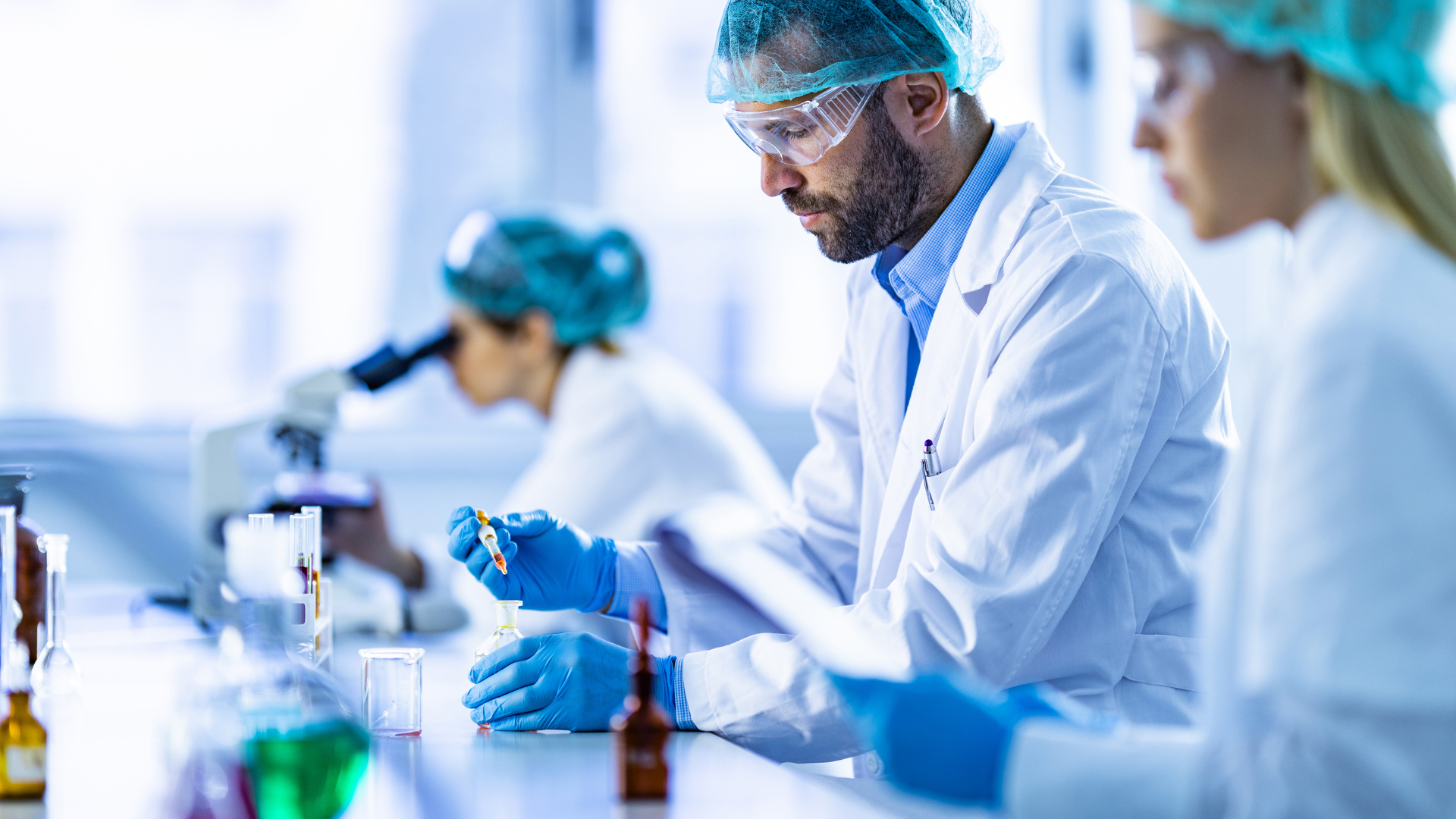 Laboratory professionals using workstations to conduct testing and research, illustrating standard versus custom workstation solutions for operational efficiency.
