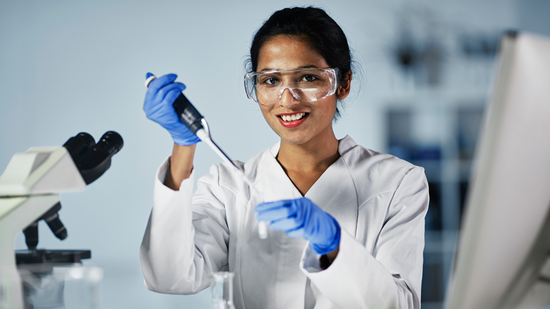 Laboratory technician working at a technical workstation, illustrating the need for custom industrial workbenches to improve workflow and productivity.