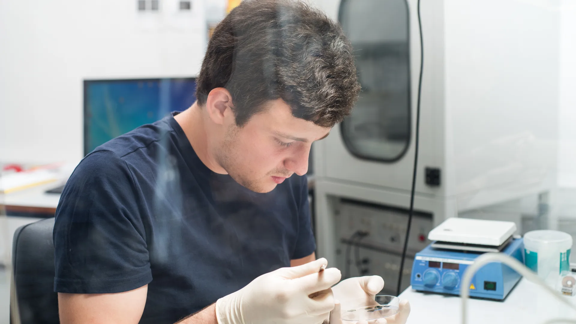 Technician working at a custom semiconductor manufacturing workstation designed for precision, efficiency, and process-specific tasks.